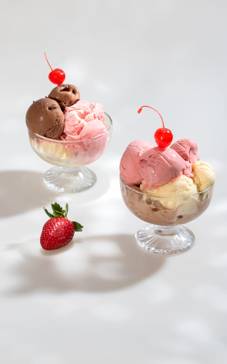 Dos copas de helado con cereza y fresa