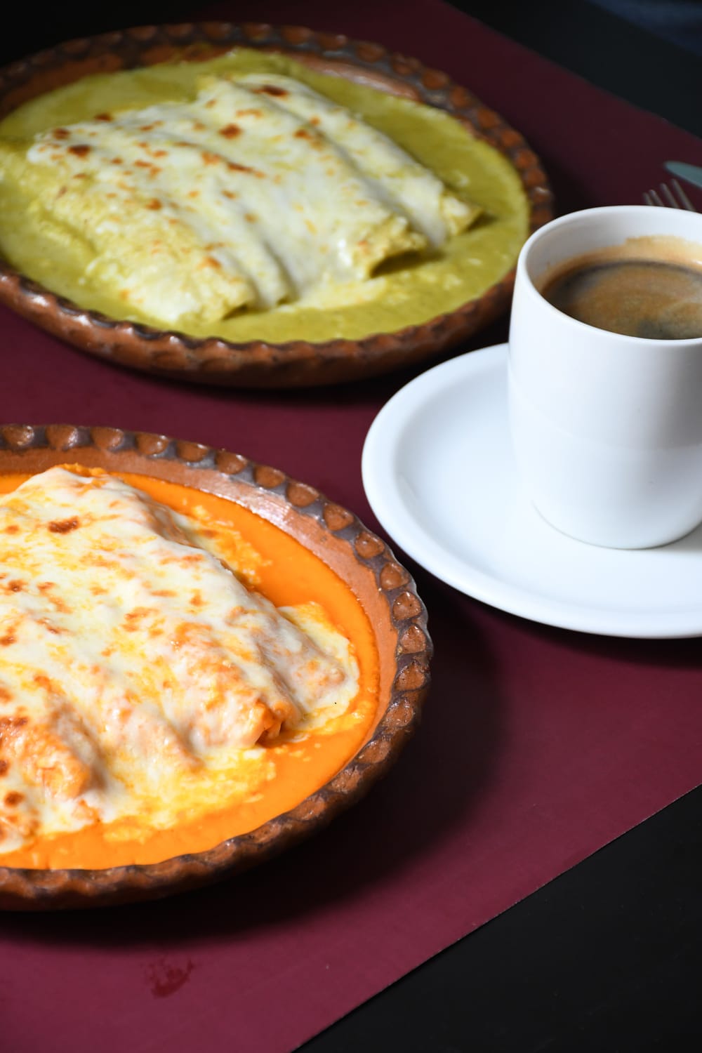 Enchiladas verdes y rojas gratinadas servidas con café
