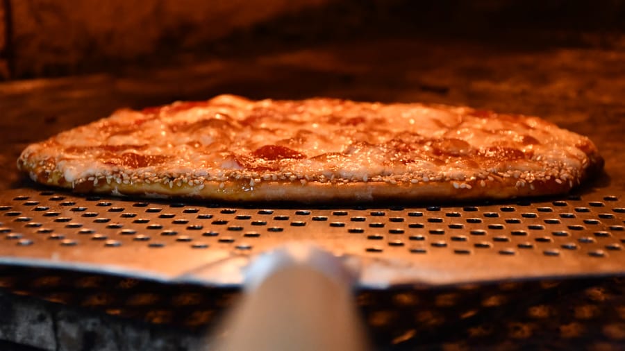Pizza recién horneada saliendo del horno